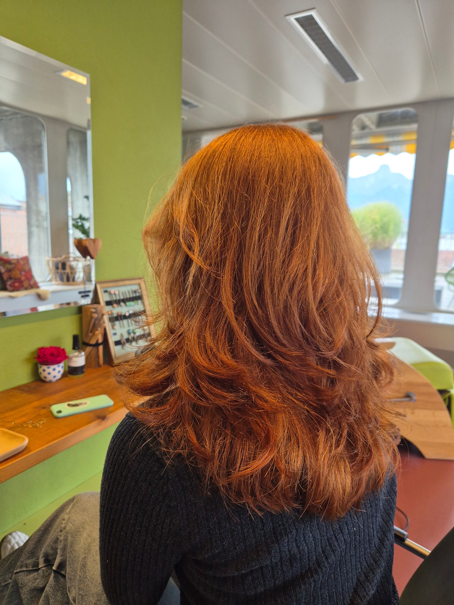 Frau bei der Anwendung von YELASAI Haarpflegeprodukten.“