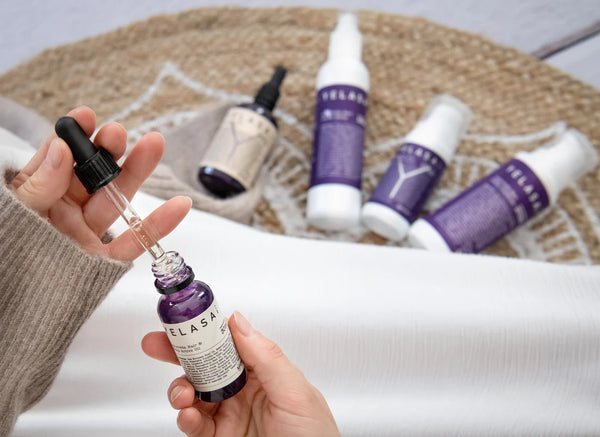 Die Produkte on YELASAI im HIntergund und eine Person die das Auyurveda Hair Scalp Active Oil benutzt.