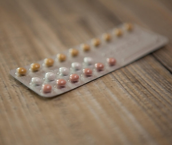 Tabletten auf Tisch um Haarausfall zu stoppen
