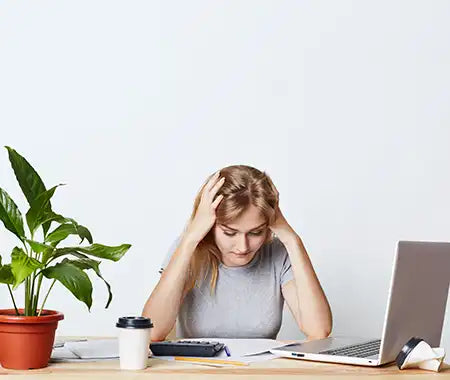 Frau gestresst beim arbeiten